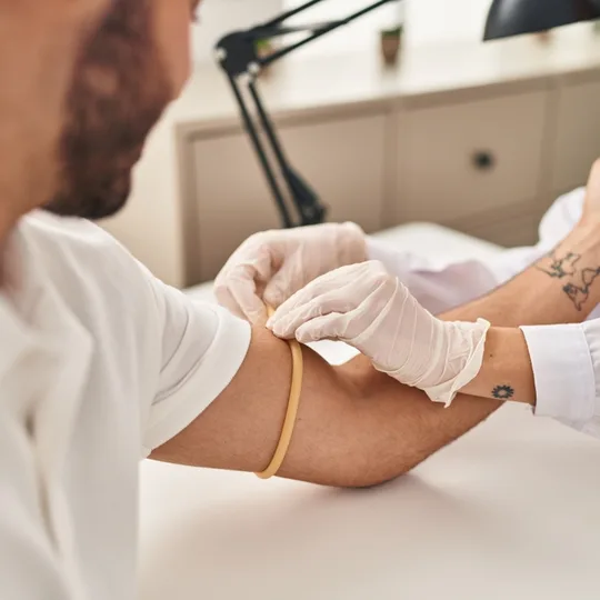 Practitioner preparing a patient's arm for a blood draw