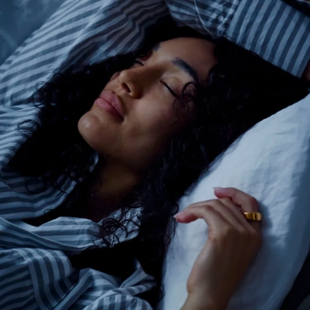 Person resting in bed with Oura Ring, representing sleep and recovery insights